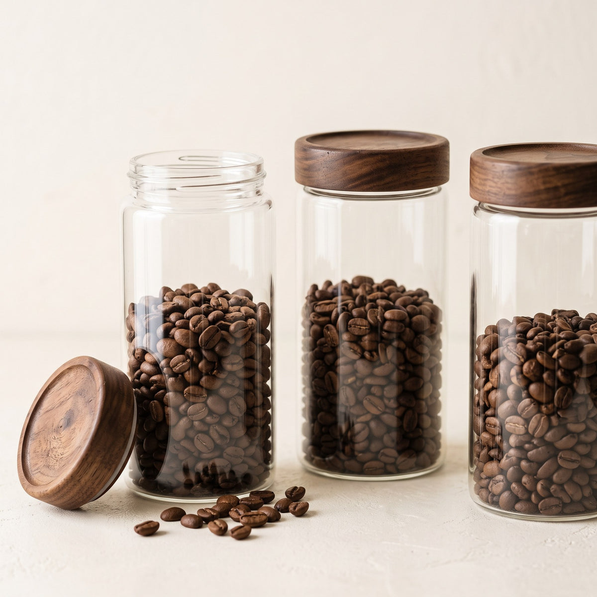 Glass dosing jars with walnut lids holding single doses of whole coffee beans