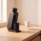 CAFOVO G255CV coffee grinder on a wooden counter beside a cup