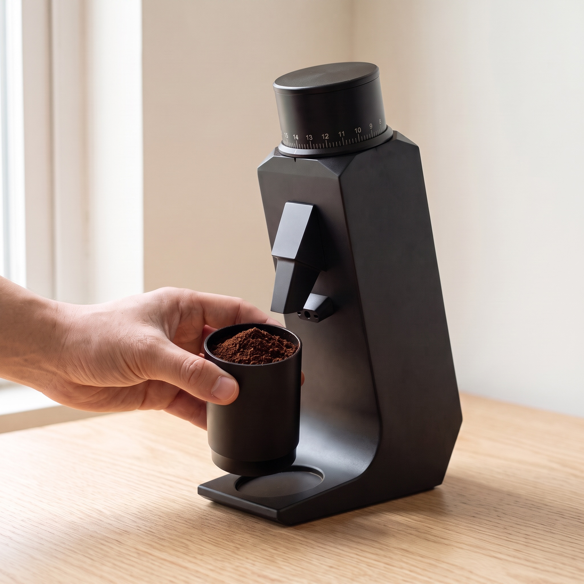 Hand placing the dosing cup under the CAFOVO G255CV grinder