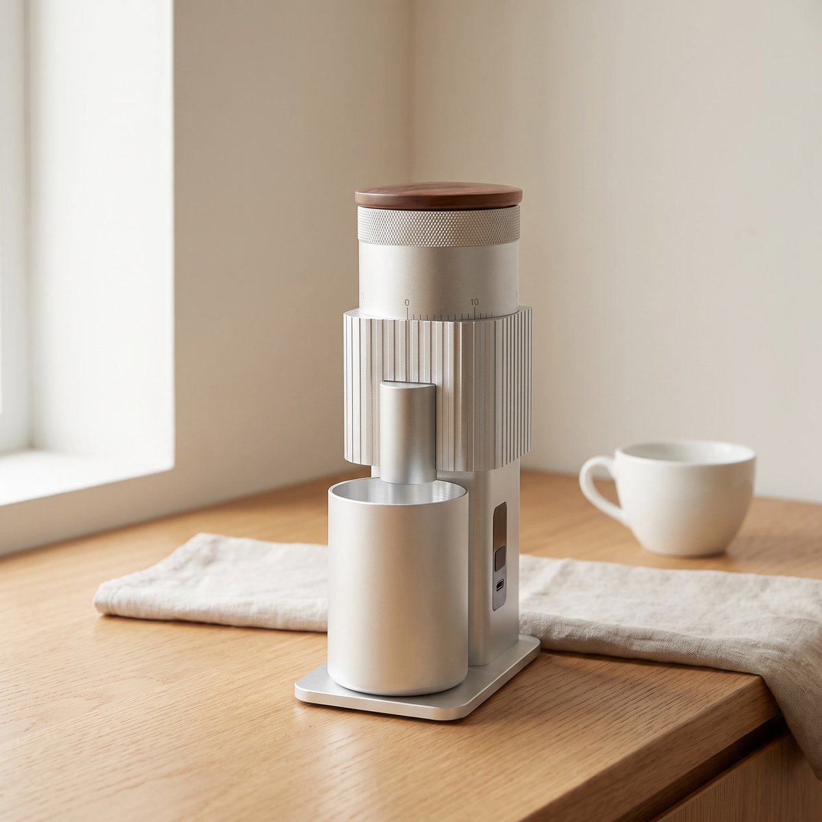 Silver CF Wisdom portable burr coffee grinder with walnut lid on a kitchen counter