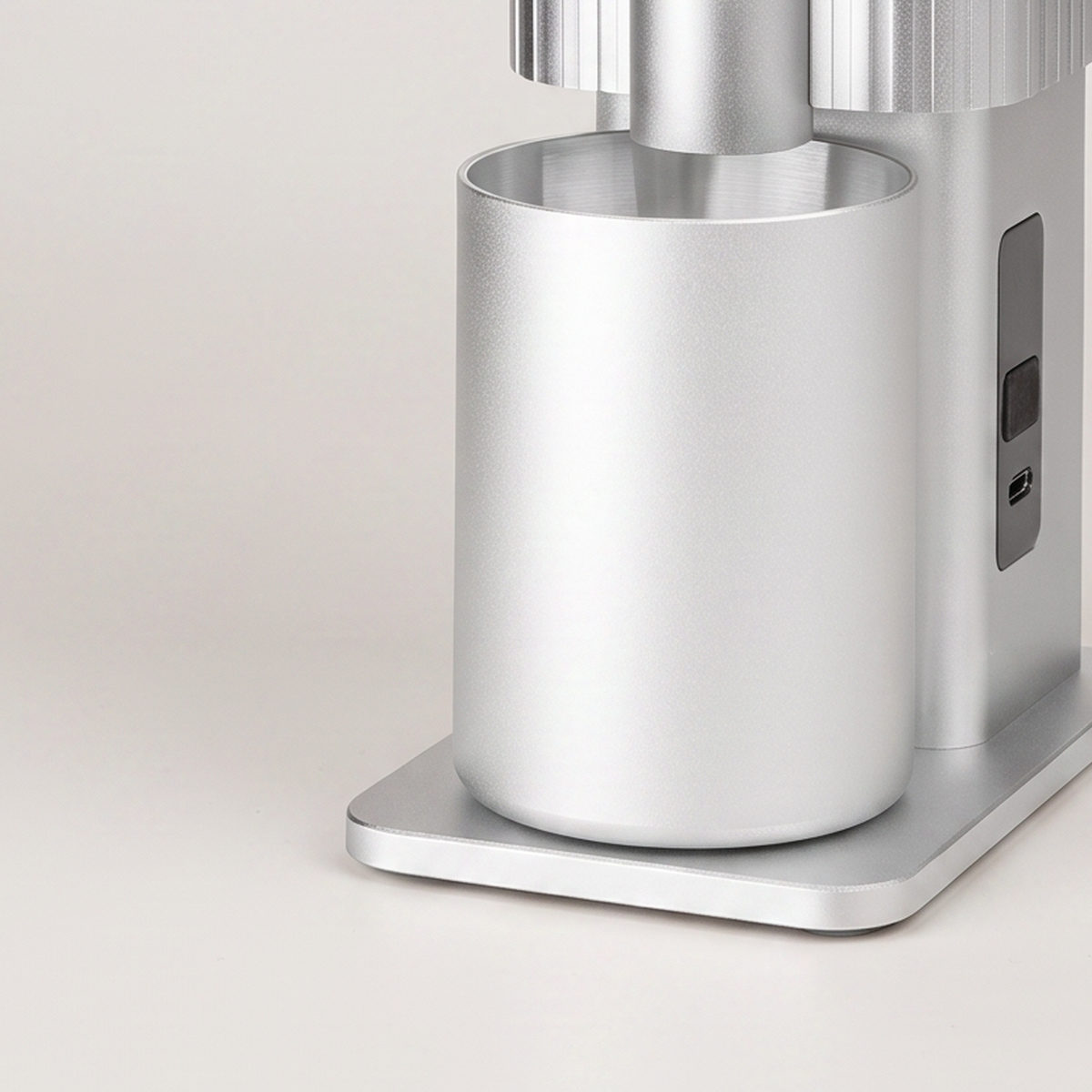 Close-up of the grounds cup and control panel of the silver CF Wisdom grinder