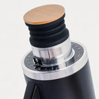 Close-up of the bamboo lid and graduated ring of the black DF54 grinder