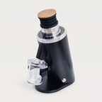 DF54 coffee grinder in black, three-quarter view with the clear grounds cup attached
