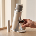 Hand lifting the dosing cup with ground coffee from the single dose grinder