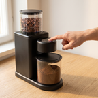 Finger pressing a button on the touch panel of the Wancle CBG-9001 coffee grinder